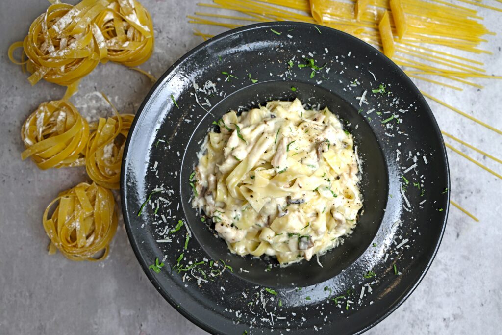 Keto chicken Alfredo casserole with melted mozzarella cheese, garnished with fresh parsley. A creamy, low-carb comfort meal.