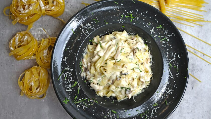 Keto chicken Alfredo casserole with melted mozzarella cheese, garnished with fresh parsley. A creamy, low-carb comfort meal.