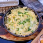 Creamy low-carb cauliflower mac and cheese served in a bowl, garnished with fresh chives and breadcrumbs. A healthier twist on the classic comfort dish.