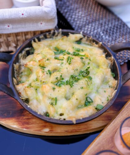 Creamy low-carb cauliflower mac and cheese served in a bowl, garnished with fresh chives and breadcrumbs. A healthier twist on the classic comfort dish.