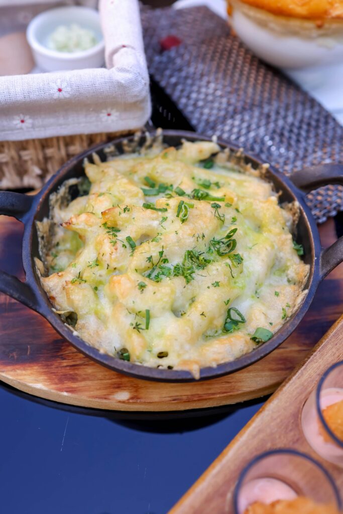 Creamy low-carb cauliflower mac and cheese served in a bowl, garnished with fresh chives and breadcrumbs. A healthier twist on the classic comfort dish.