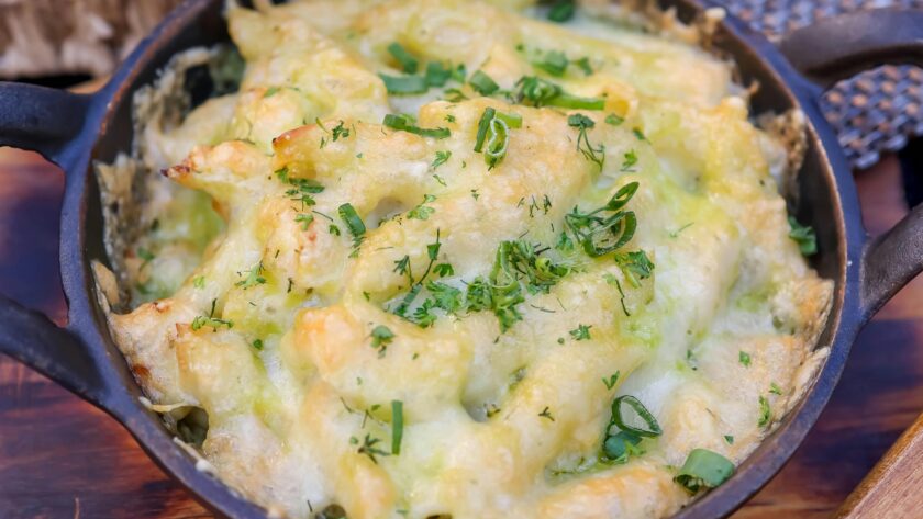 Creamy low-carb cauliflower mac and cheese served in a bowl, garnished with fresh chives and breadcrumbs. A healthier twist on the classic comfort dish.