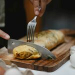 cutting egg roll with Fork and knife.