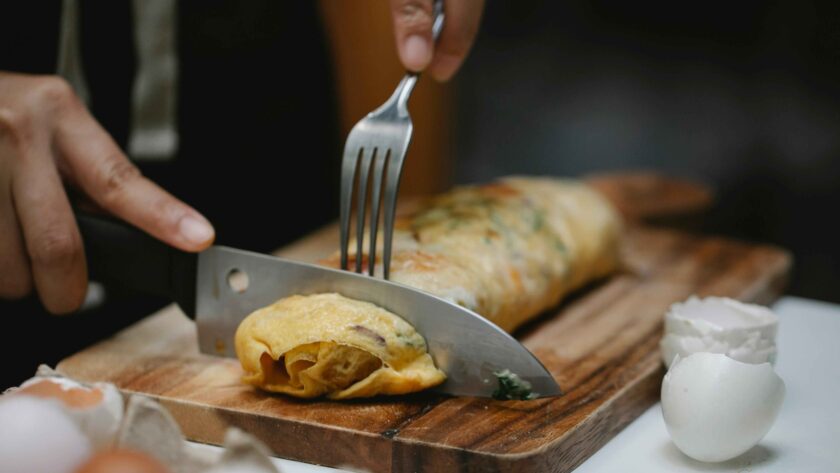 cutting egg roll with Fork and knife.