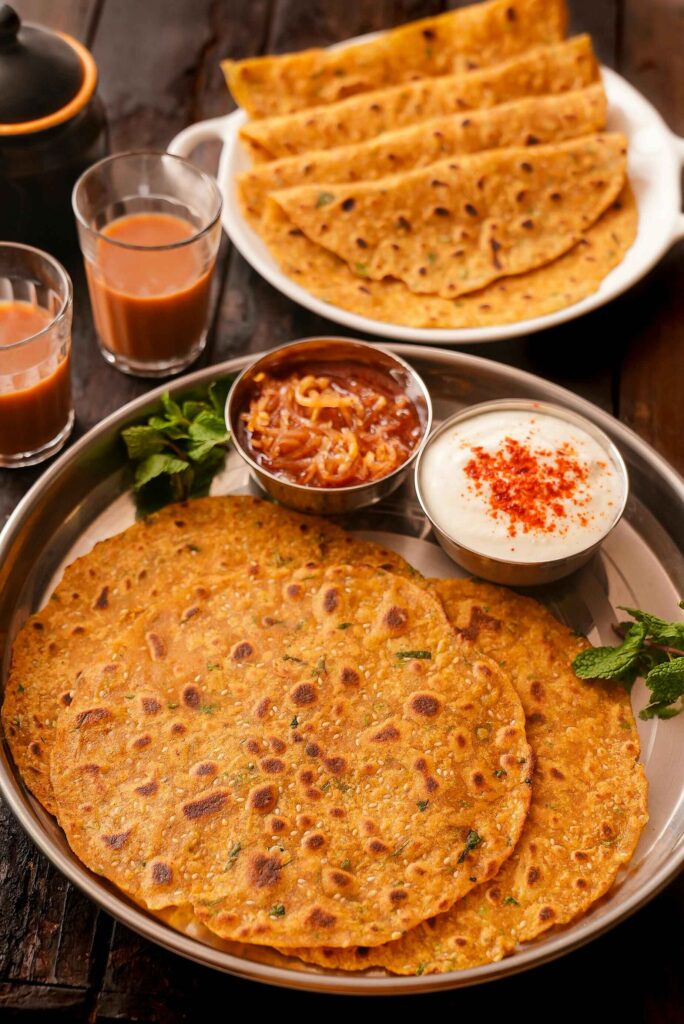 chilla served on plate with curd and tea