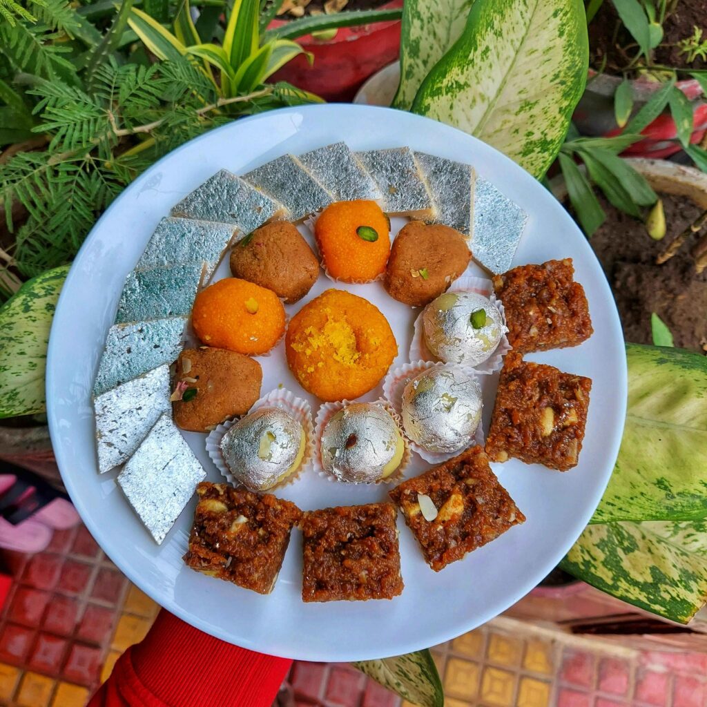 Kaju Barfi and Other Sweets served in a white plate.