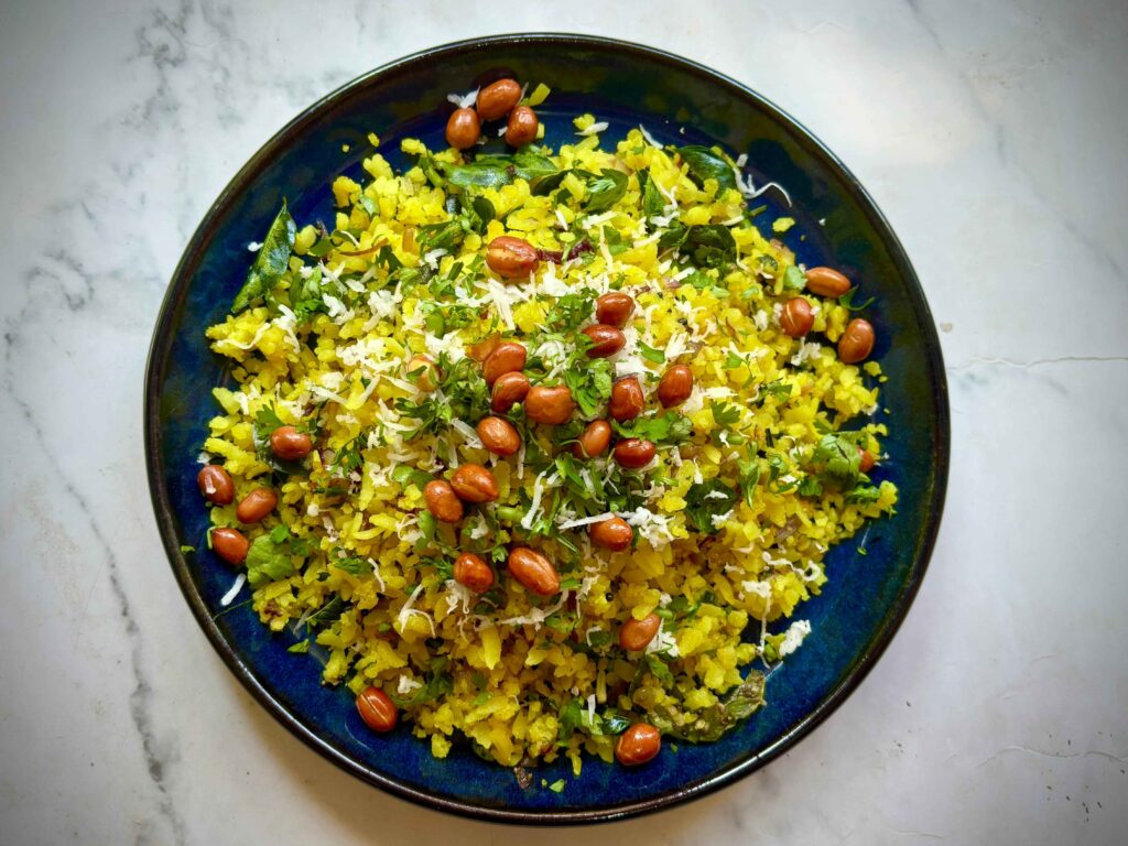 Best Homemade Poha serves on a black plate