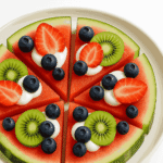 Watermelon fruit pizza served on a white plate