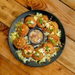 Dahi Puri served on a black plate