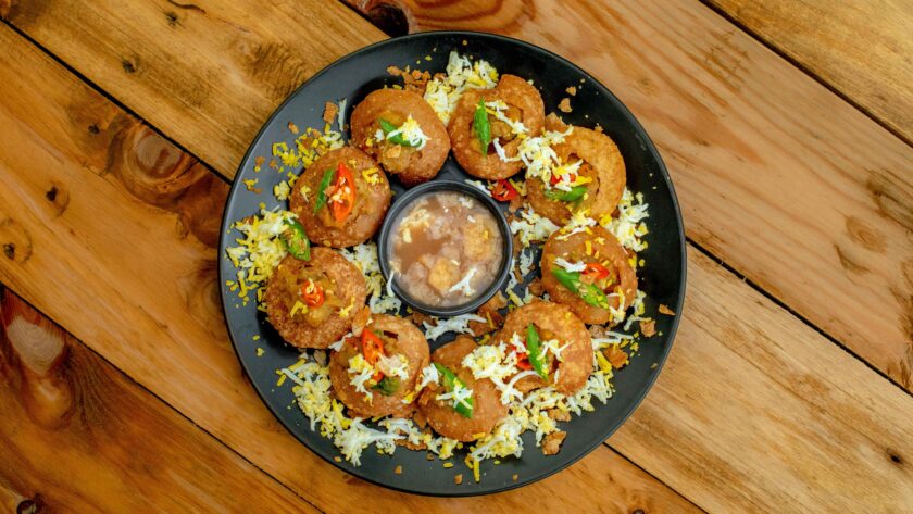 Dahi Puri served on a black plate