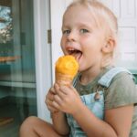 A girl is eating Mango Ice Cream