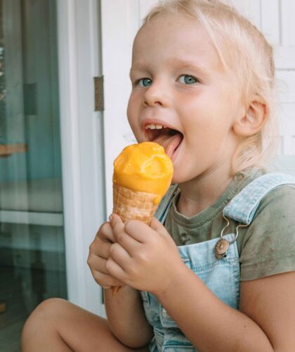 A girl is eating Mango Ice Cream
