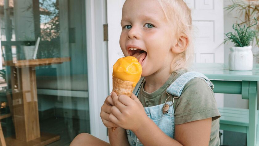 A girl is eating Mango Ice Cream