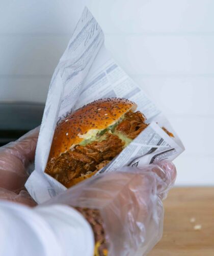 A person is holding Pork Burger