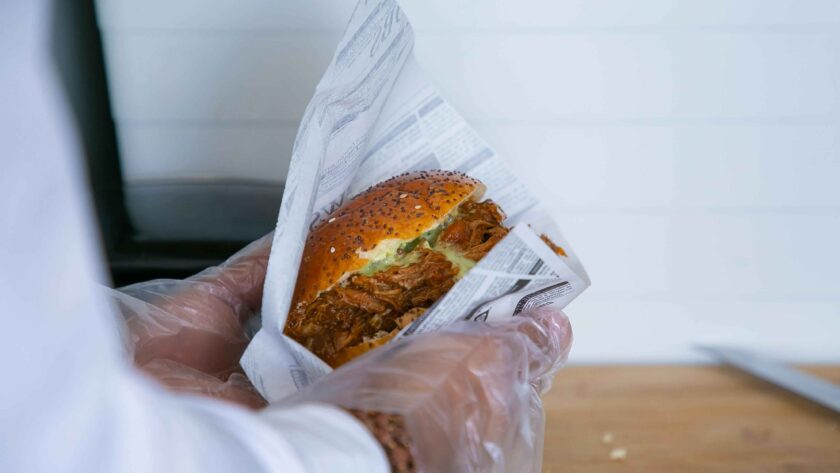 A person is holding Pork Burger